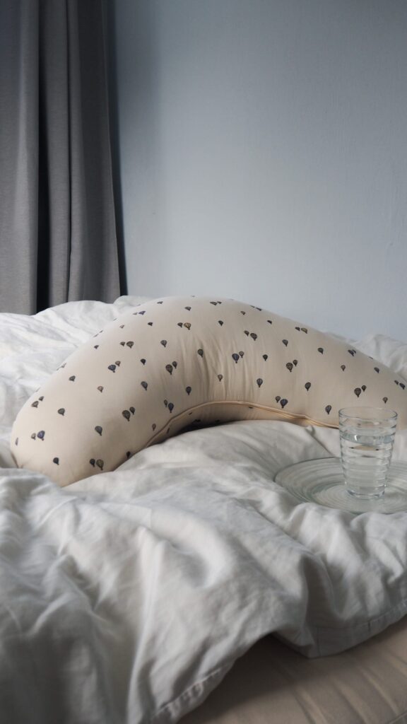 Blødt babynet i gråt, baby ligger på blegebams, udendørs, trygt og hyggeligt.