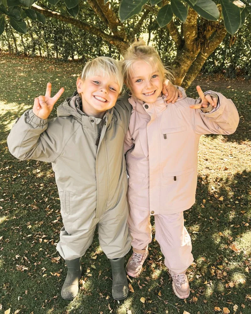 Havejende børn i forårstøj leger under et træ, Begynderbaby.