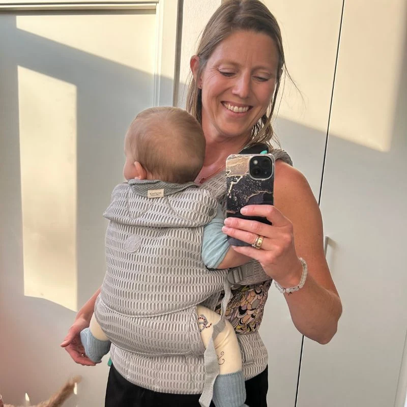 babybæresele, mor med baby i bæresele,  nærhed, moderne babyudstyr, Begynderbaby, børnefamilie, hyggeligt øjeblik, komfortabel bæresele, trendy babybæring, ergonomisk design.